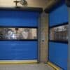 Blue high-speed industrial doors with clear windows and safety guards