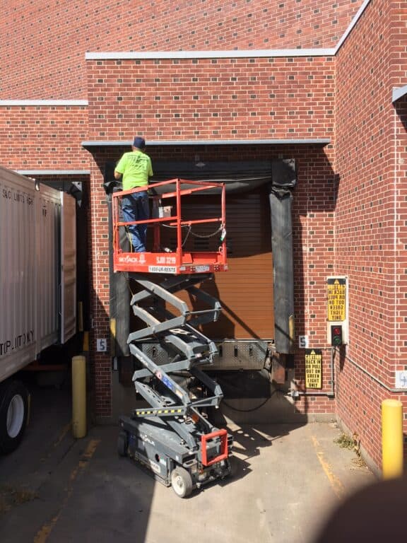 guy on a scissor lift working on a dock seal