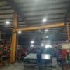 314 series freestanding jib crane with drop-style boom and electric hoist installed inside an industrial facility.