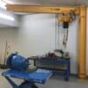 314 series freestanding jib crane equipped with a Tiger Track enclosed track hoist system in an industrial workspace.