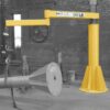 Freestanding 350AJ series articulating jib crane with 550 lb capacity shown in an industrial setting with highlighted yellow crane structure.